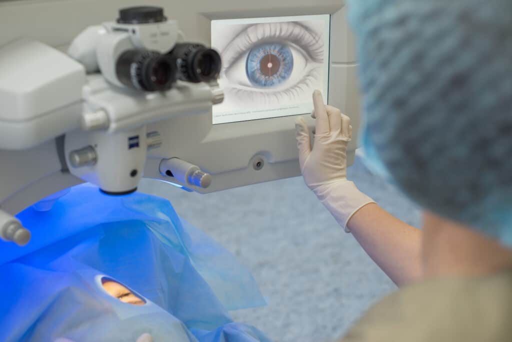 Doctor ophthalmologist, pressing the button on the control display to start a modern laser for the correction of visual impairment. Laser eye microsurgery. Treatment of cataracts, myopia, anisocoria, astigmatism, myopia, strabismus in patients using modern equipment.